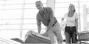 Image of couple picking up suitcase at the airport