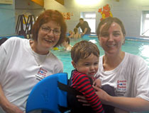 Photo de deux femmes en compagnie d’un enfant dans le cadre du programme Swimstart